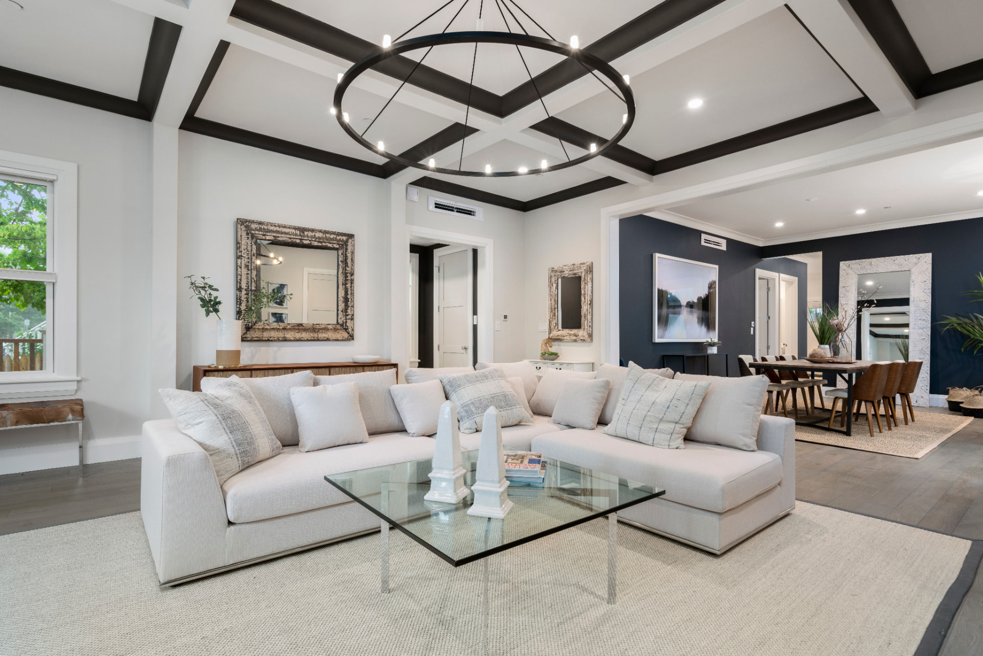 Open living room painted in soft white beside a navy dining room