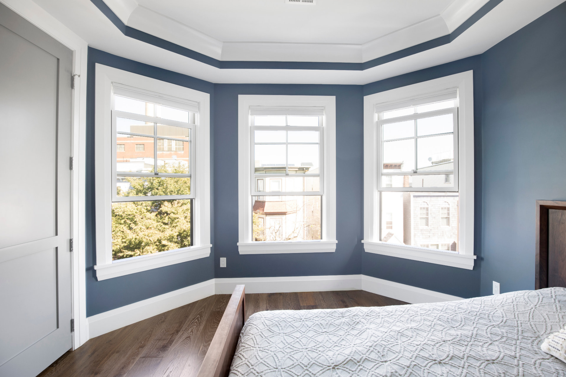 Bedroom painted in a deep blue accent color with white trim