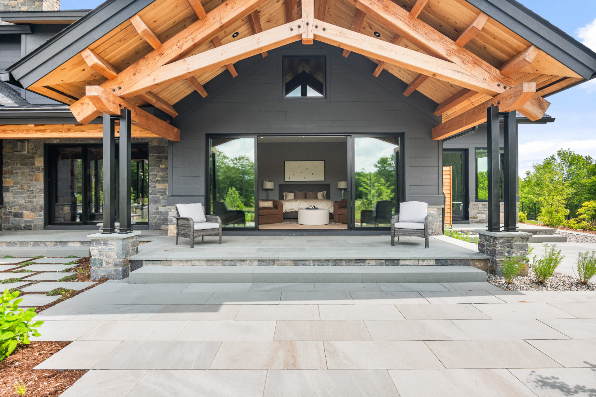 Covered porch with timber trusses and dark painted siding