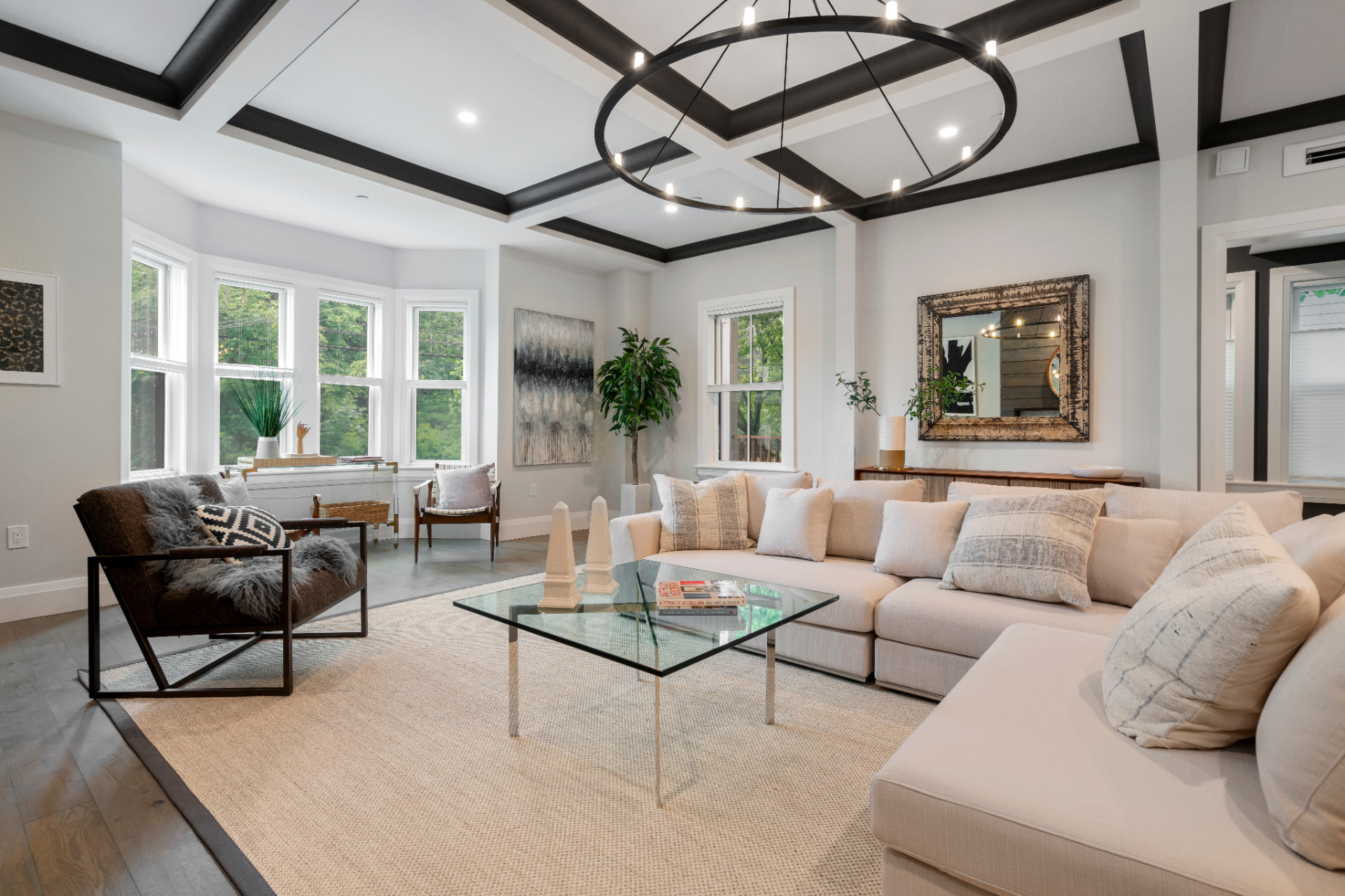 Bay-window living room with white walls and dark ceiling beams